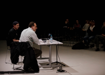 Richard Hawkins in conversation with Christian Liclair
                                          at a table in an event hall in front of an audience