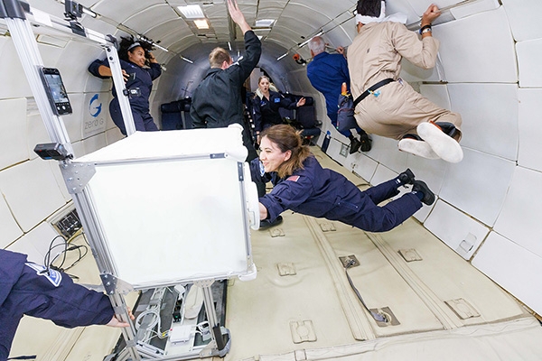 Eine Gruppe Astronautinnen schwebt in einer Weltraumkapsel